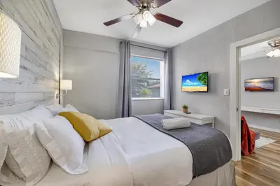 a bedroom with a white bed with a ceiling fan at Seascape - Mins to Las Olas & Beach in Fort Lauderdale