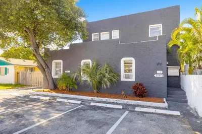 a gray house with a parking lot in front of it at Seascape - Mins to Las Olas & Beach in Fort Lauderdale