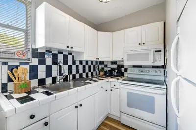 a kitchen with white cabinets and a sink at Seascape - Mins to Las Olas & Beach in Fort Lauderdale