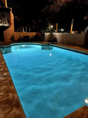 a large blue swimming pool at night at Luxury Pool Villa at St. James UNIT E, Pet Friendly in Miami