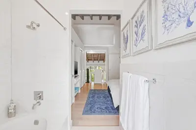 a bathroom with a white tub and a blue rug at Luxury Pool Villa at St. James UNIT E, Pet Friendly in Miami