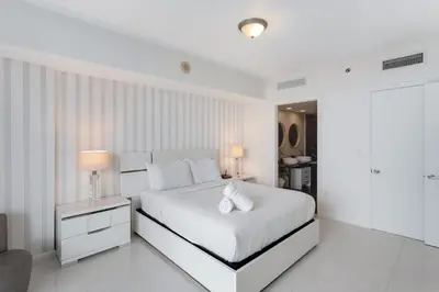 a white bedroom with a white bed with two pillows at ICON W BRICKELL BY IMD MIAMI Elegant River View 1BR 1BA in Miami