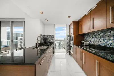 a kitchen with wooden cabinets and a large window at ICON W BRICKELL BY IMD MIAMI Marvelous Ocean View 2BR/2BA in Miami