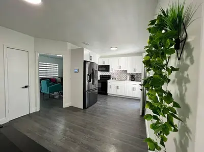 a kitchen with white cabinets and a black refrigerator at Stylish 3/2 centrally located! in Miami
