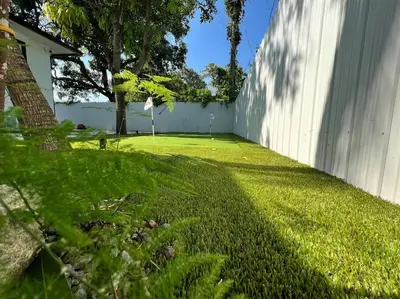 a yard with a white fence and a grass field at Stylish 2/1 centrally located! in Miami