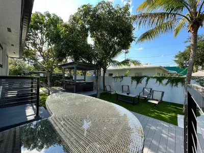 a white rattan table on a patio with palm trees at Stylish 2/1 centrally located! in Miami