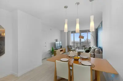 a dining room and living room with a wooden table and chairs at Amazing view - Balcony - Gym - Pool in Hallandale Beach