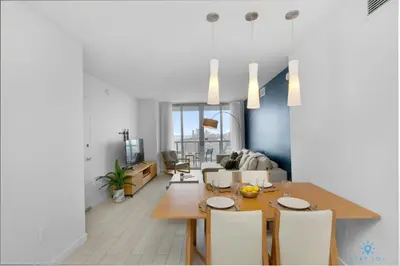 a dining room and living room with a table and chairs at Amazing view - Balcony - Gym - Pool in Hallandale Beach