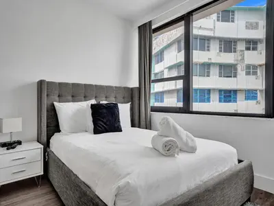 a bedroom with a large bed with a window at Gorgeous Miami Beach Condo Beach Service 1614 in Miami Beach