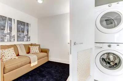 a living room with a couch and a washing machine at Tiffany Emerald - Rooftop Pool, Gym, & Walk to Beach in Fort Lauderdale