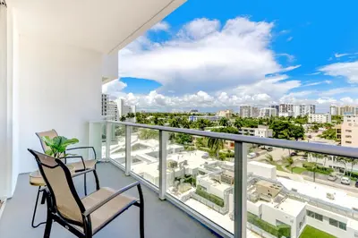 a balcony with two chairs and a view of the city at Tiffany Emerald - Rooftop Pool, Gym, & Walk to Beach in Fort Lauderdale