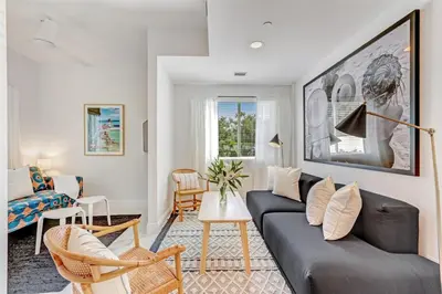 a living room with a black couch and chairs at Wynwood Jumbo - Sleeps 16 & free parking in Miami