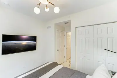 a bedroom with a bed and a tv on a wall at Wynwood Jumbo - Sleeps 16 & free parking in Miami