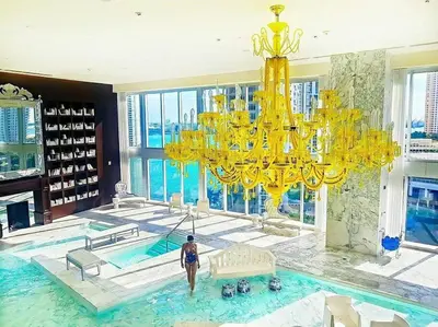 a woman standing in a swimming pool with a large chandelier at Studio at Icon Brickell Luxury Waterfront Building in Miami