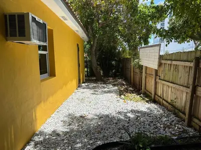 a yellow building with a window and a fence at Stylish StudioBrickellLittle Havana-ItalianPlaza in Miami