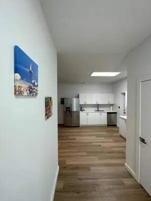 a large kitchen with white cabinets and a wooden floor at Stylish StudioBrickellLittle Havana-ItalianPlaza in Miami