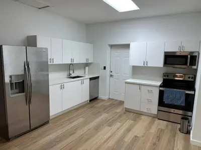 a kitchen with white cabinets and stainless steel appliances at Stylish StudioBrickellLittle Havana-ItalianPlaza in Miami