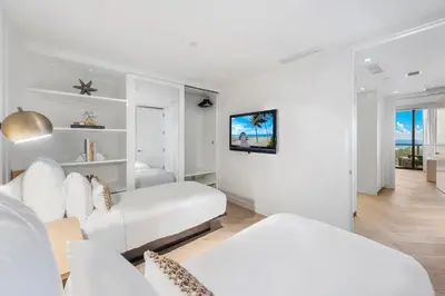 a white living room with a couch and a tv at 2B Ocean View Private Residence at South Beach - 804 in Miami Beach