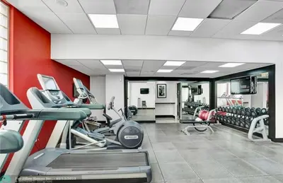 a gym with several treadmills and machines in a room at Condo, Breathtaking Water views, King Suite, Hilton Property in Fort Lauderdale
