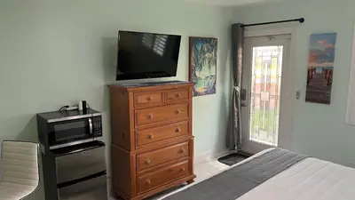 a bedroom with a television on a dresser with a microwave at Billy's Resort- Men Only - Solo Hombres in Wilton Manors