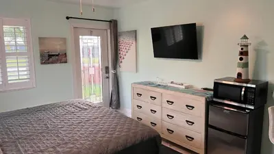 a bedroom with a bed and a microwave on a dresser at Billy's Resort- Men Only - Solo Hombres in Wilton Manors