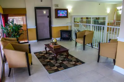 a living room with chairs and a table and a fireplace at Fort Lauderdale Beach Resort by Vacatia in Fort Lauderdale