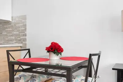 a table with two chairs and a vase with red flowers at Lovely condo in Miami Beach in Miami Beach