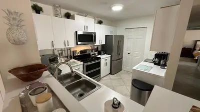 a kitchen with a sink and a stove top oven at Deluxe Yacht Club Condo Near the Beach in Miami