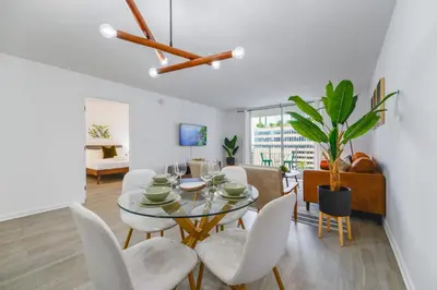a dining room with a glass table and white chairs at Condo with Panoramic City Views in Brickell in Miami