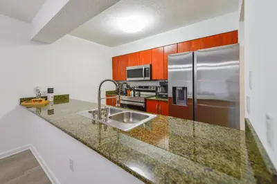 a kitchen with a sink and a stainless steel refrigerator at Condo with Panoramic City Views in Brickell in Miami