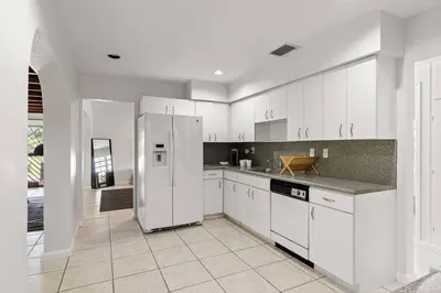 a kitchen with white cabinets and a refrigerator at 3br Oasis near Coral Gable in Miami