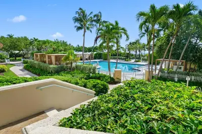 a resort pool with palm trees and bushes at Stylish Suite to Have a Great Stay! in Miami
