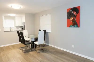 a dining room with a table and a painting on the wall at Cozy and Modern Vacation Home in Hallandale Beach