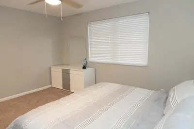 a white bedroom with a bed and a window at Cozy and Modern Vacation Home in Hallandale Beach