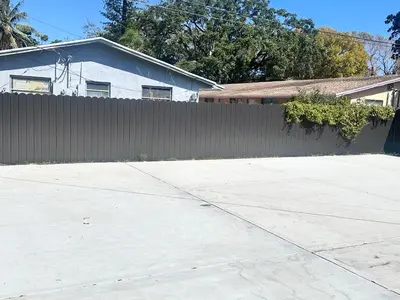 a fence in front of a house and a driveway at Cozy and Modern Vacation Home in Hallandale Beach