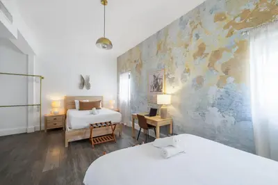 a bedroom with two beds and a wall with a mural at Ithaca in Miami Beach