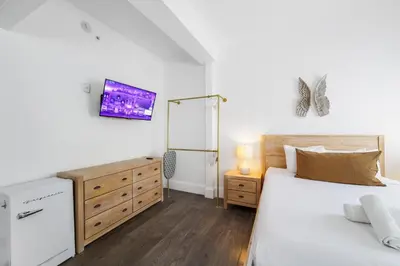 a bedroom with a bed and a dresser with a tv at Ithaca in Miami Beach