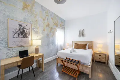 a bedroom with a bed and a desk with a laptop at Ithaca in Miami Beach