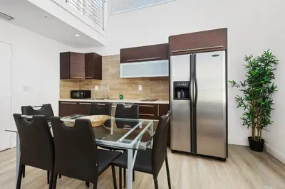 a kitchen with a table and a stainless steel refrigerator at Ocean Drive Apartment Suites in Miami Beach in Miami Beach