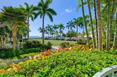a park with palm trees and bushes and the ocean at Leave the Worries Behind & Relax in Our Suite! in Miami
