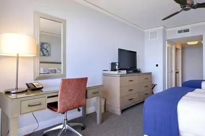 a hotel room with a bed and a desk with a television at Leave the Worries Behind & Relax in Our Suite! in Miami