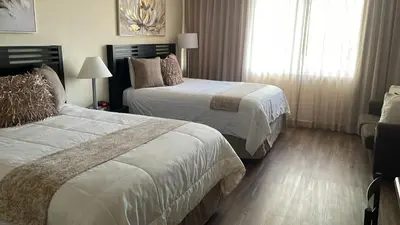 a hotel room with two beds and a window at Departamento con salida al mar Miami in Sunny Isles Beach