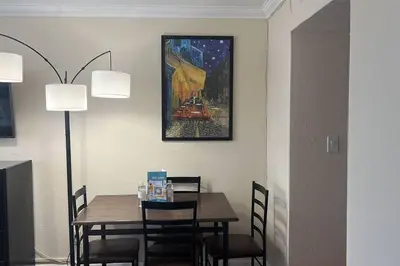 a dining room table with chairs and a painting on the wall at Departamento con salida al mar Miami in Sunny Isles Beach