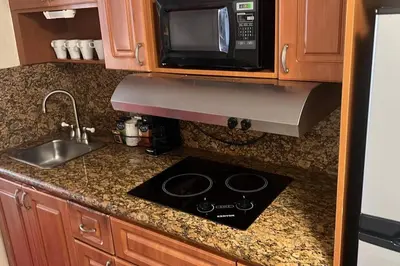 a kitchen counter with a stove and a microwave at Departamento con salida al mar Miami in Sunny Isles Beach