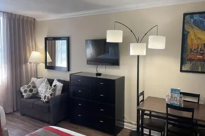 a living room with a couch and a tv and a table at Departamento con salida al mar Miami in Sunny Isles Beach
