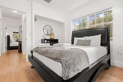 a bedroom with a large bed with a black headboard at Spacious Family 3BR Near Wynwood and Beach in Miami