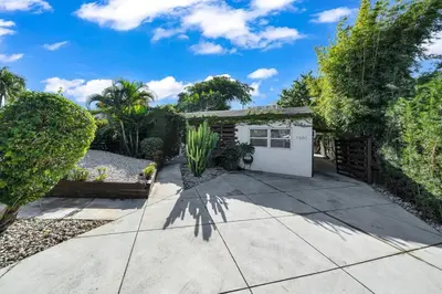 a house with a garden and a concrete driveway at Biscayne Shore #2 - 3 2 - Charming and Tropical in Miami