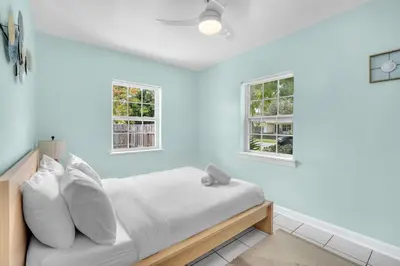 a bedroom with blue walls and a bed with white pillows at Bluewave Bungalow - #1 Charming & Comfortable 2 1 in Dania Beach