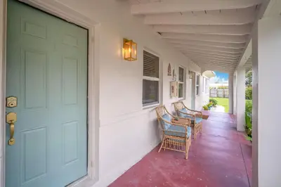 a front door of a house with chairs on a porch at Bluewave Bungalow - #1 Charming & Comfortable 2 1 in Dania Beach