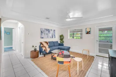 a living room with a blue couch and a table at Bluewave Bungalow - #1 Charming & Comfortable 2 1 in Dania Beach